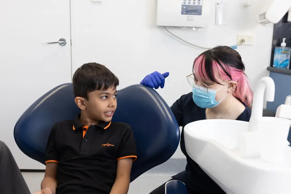 Dental assistant speaking with a child during a dental visit