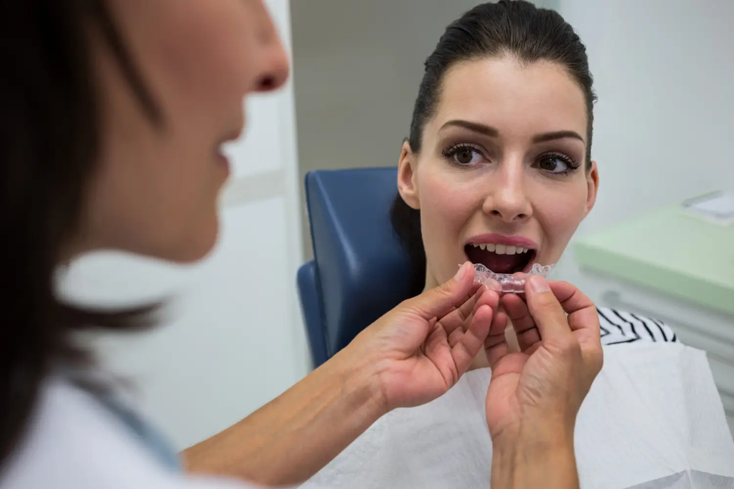 Clinician fitting clear aligners for a patient