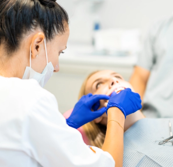 clinician examining woman in treatment chair
