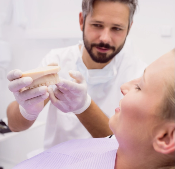 clinician holding dental model woman dental chair