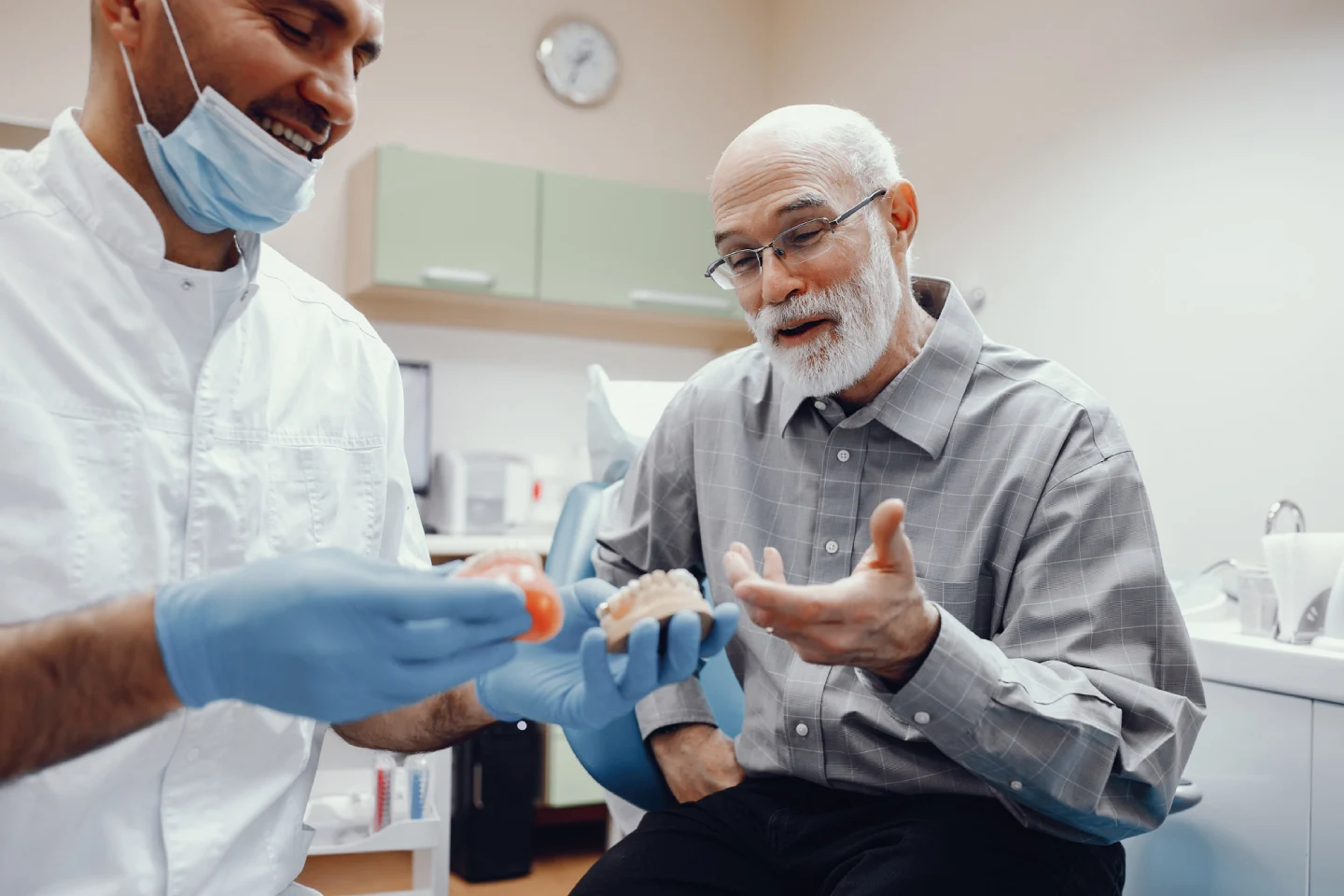 clinician holding dental models man consultation