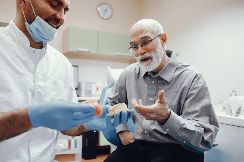 Clinician showing a custom denture to a patient during a consultation