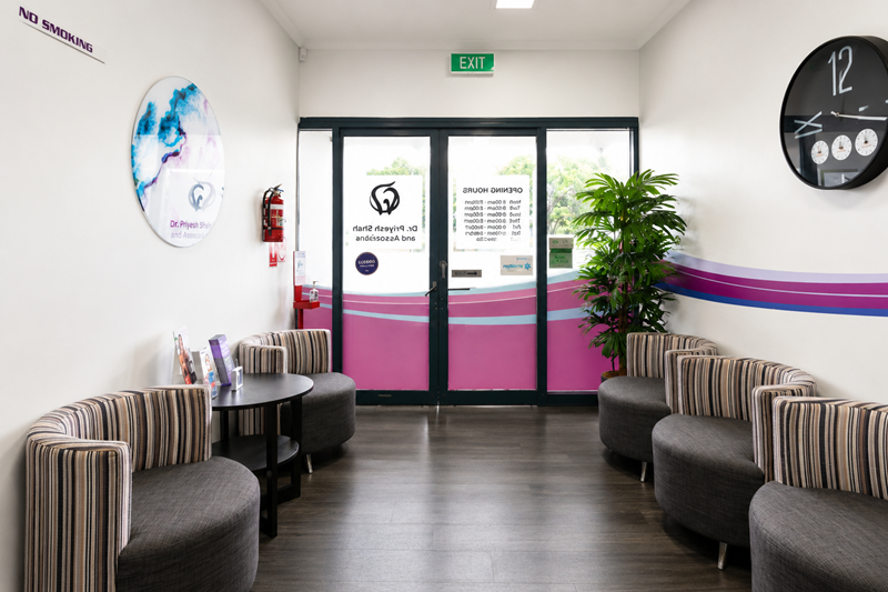 Dental clinic waiting area with seating and entrance doors