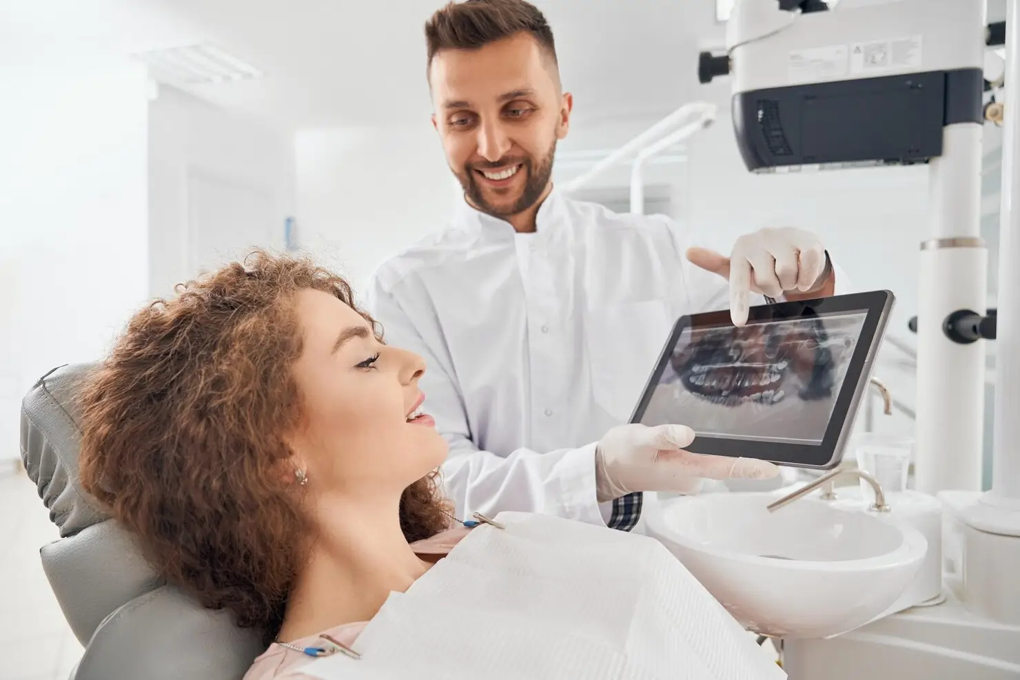 Dentist explaining a dental X-ray and treatment plan to a patient