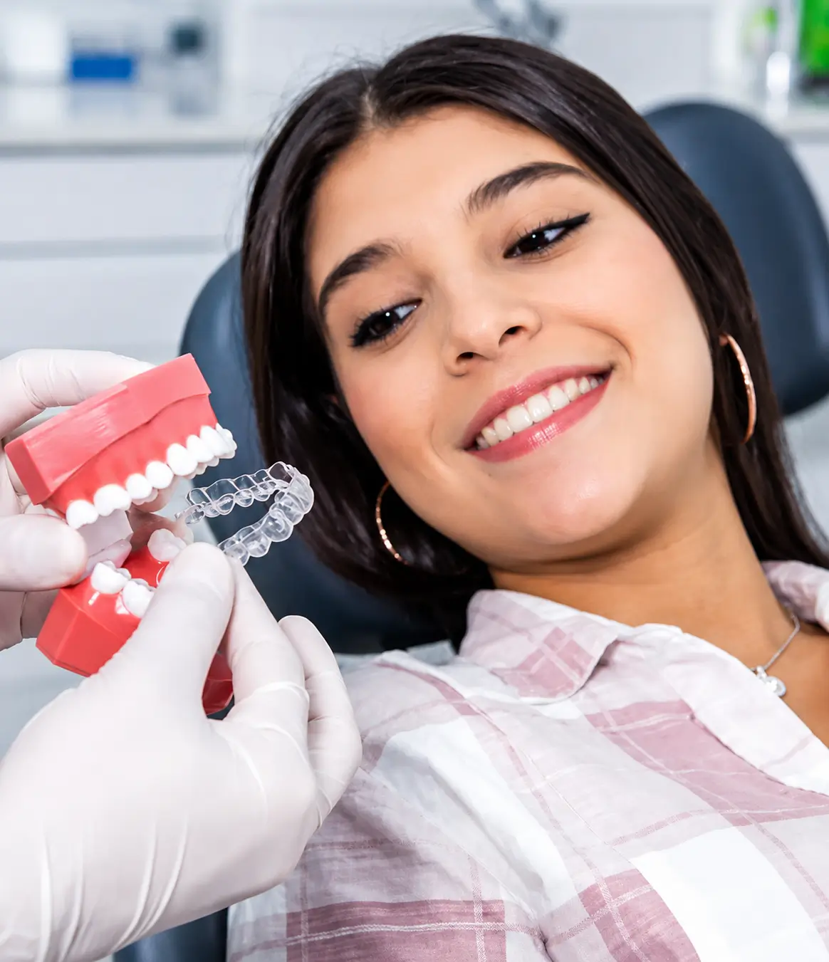 Dentist explaining Invisalign treatment using a dental model during a consultation