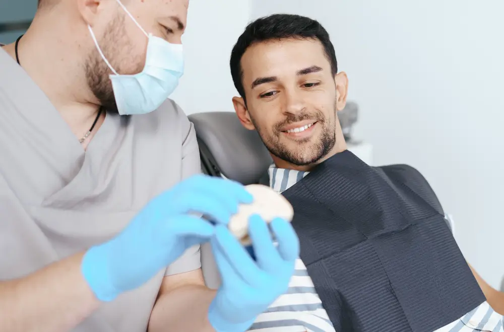 Dentist explaining treatment options using a dental model during a patient consultation