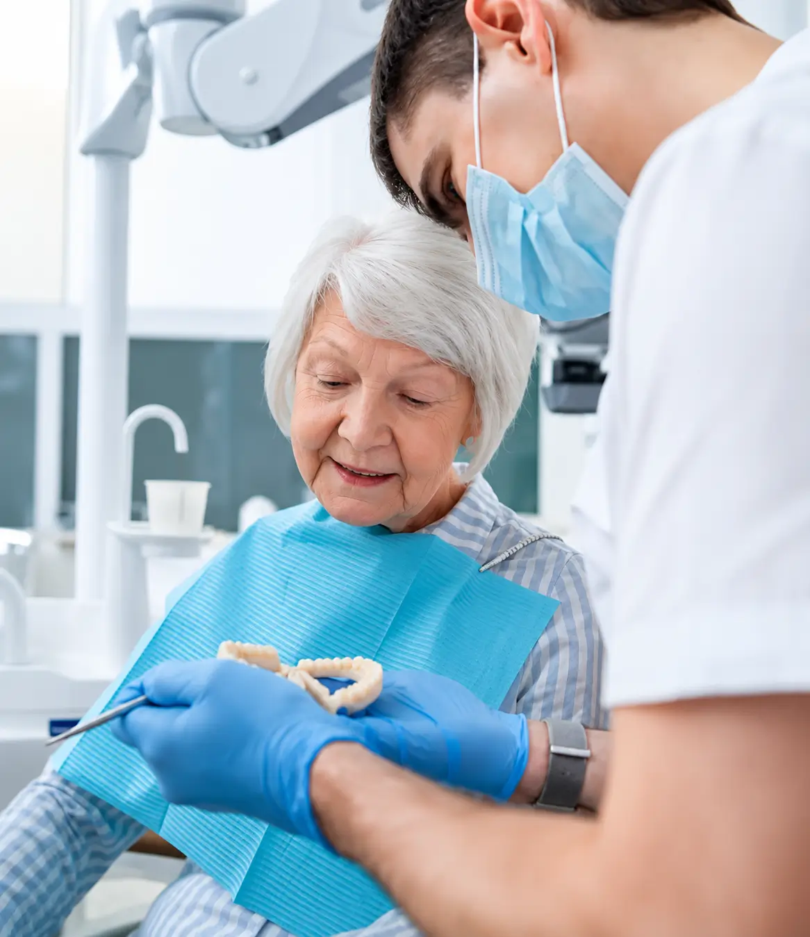 Clinician showing dentures to a patient during a consultation