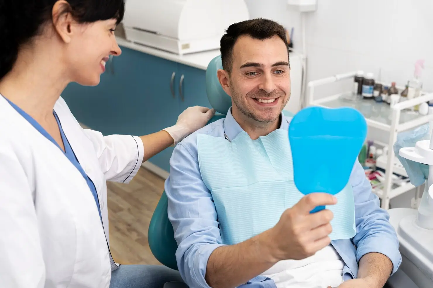 Patient checking their smile after receiving custom dentures