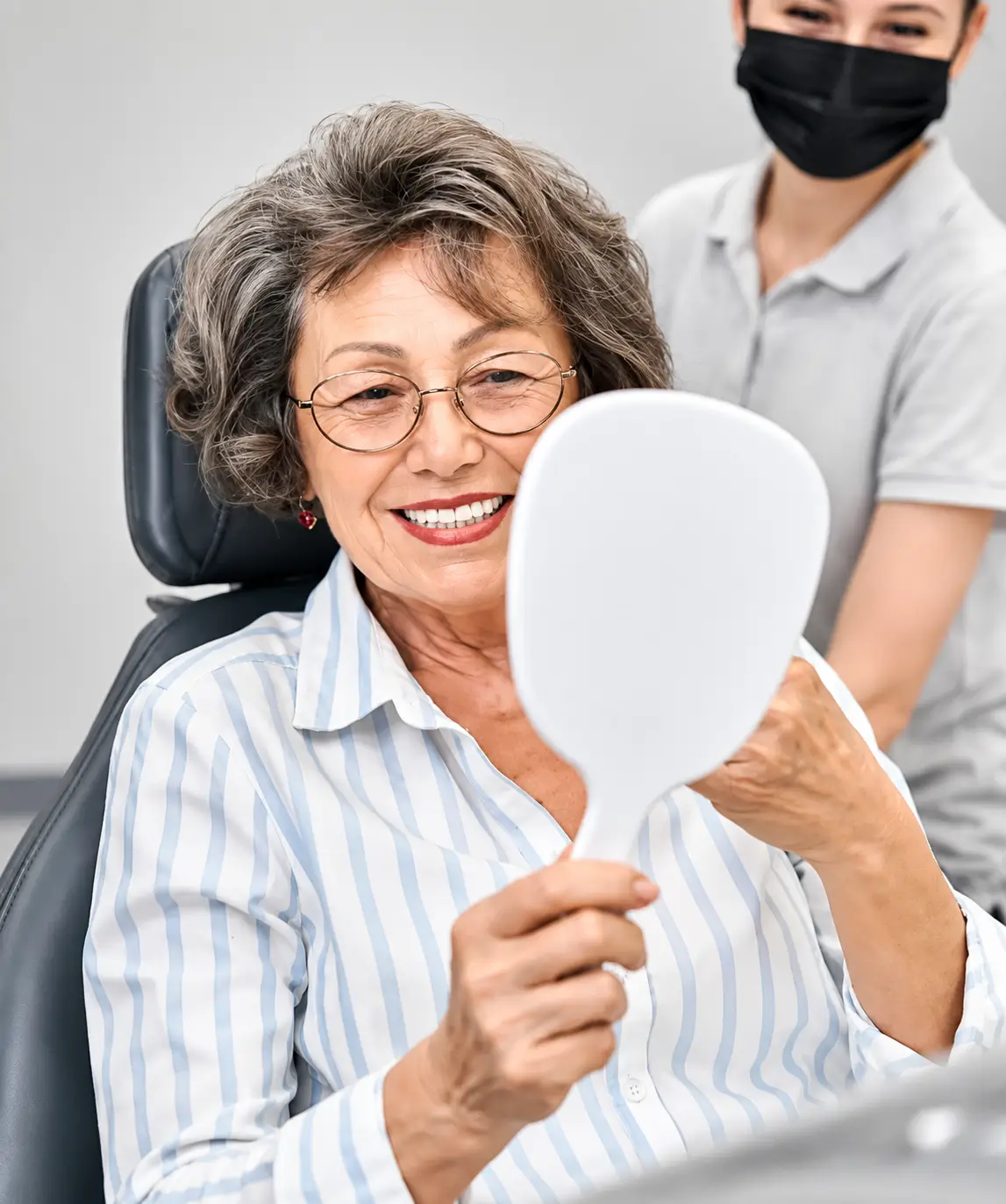 Patient checking their smile after denture treatment