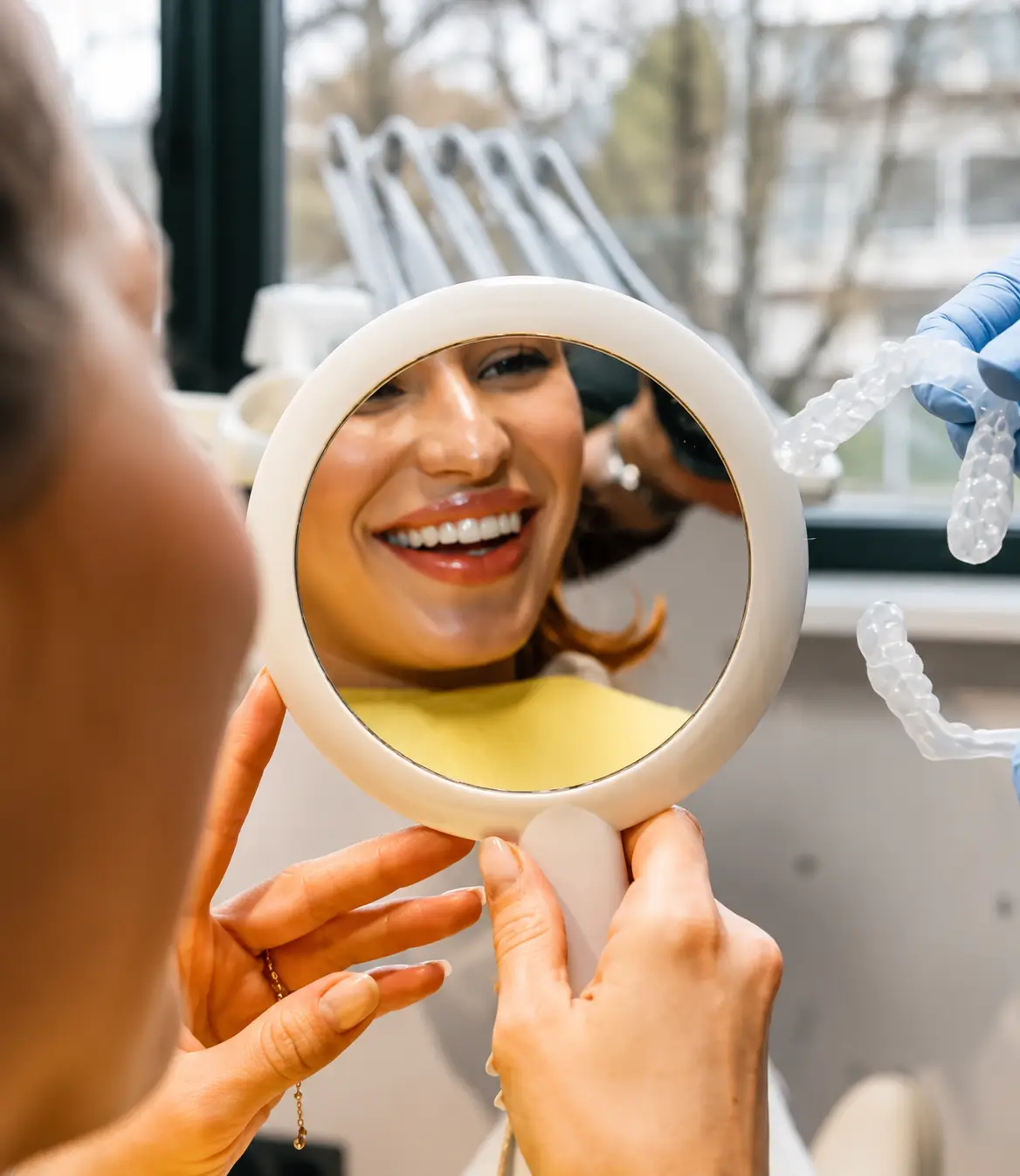 Patient smiling while reviewing clear Invisalign aligners during a consultation
