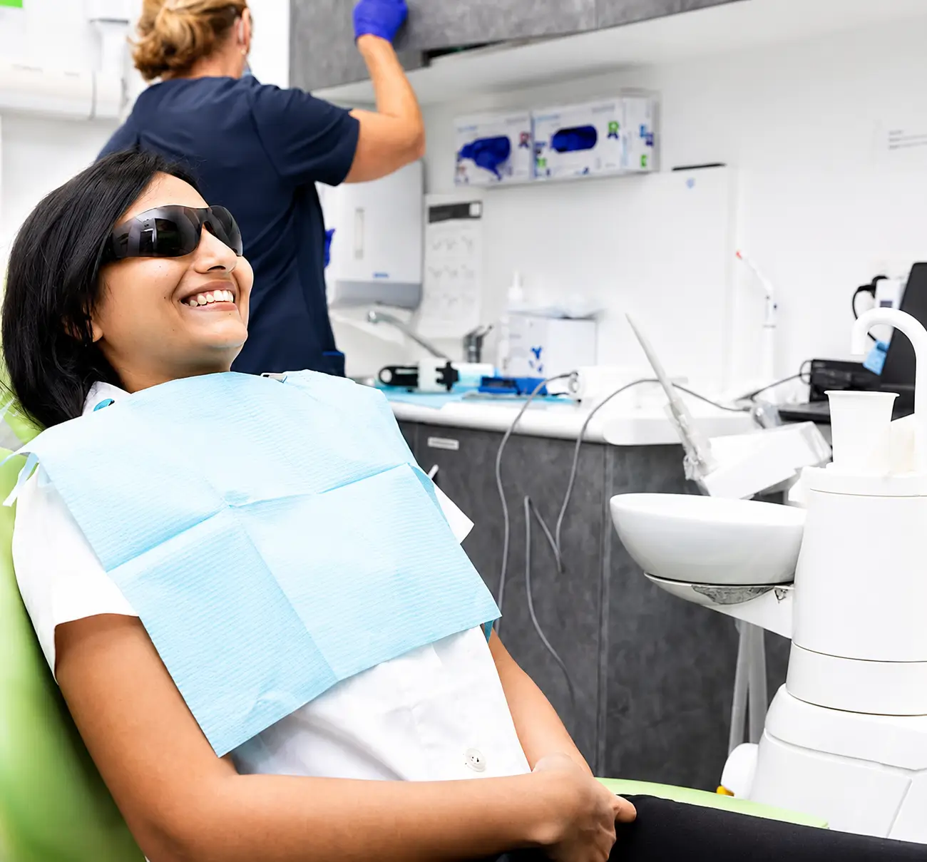 Patient wearing protective glasses in a dental chair
