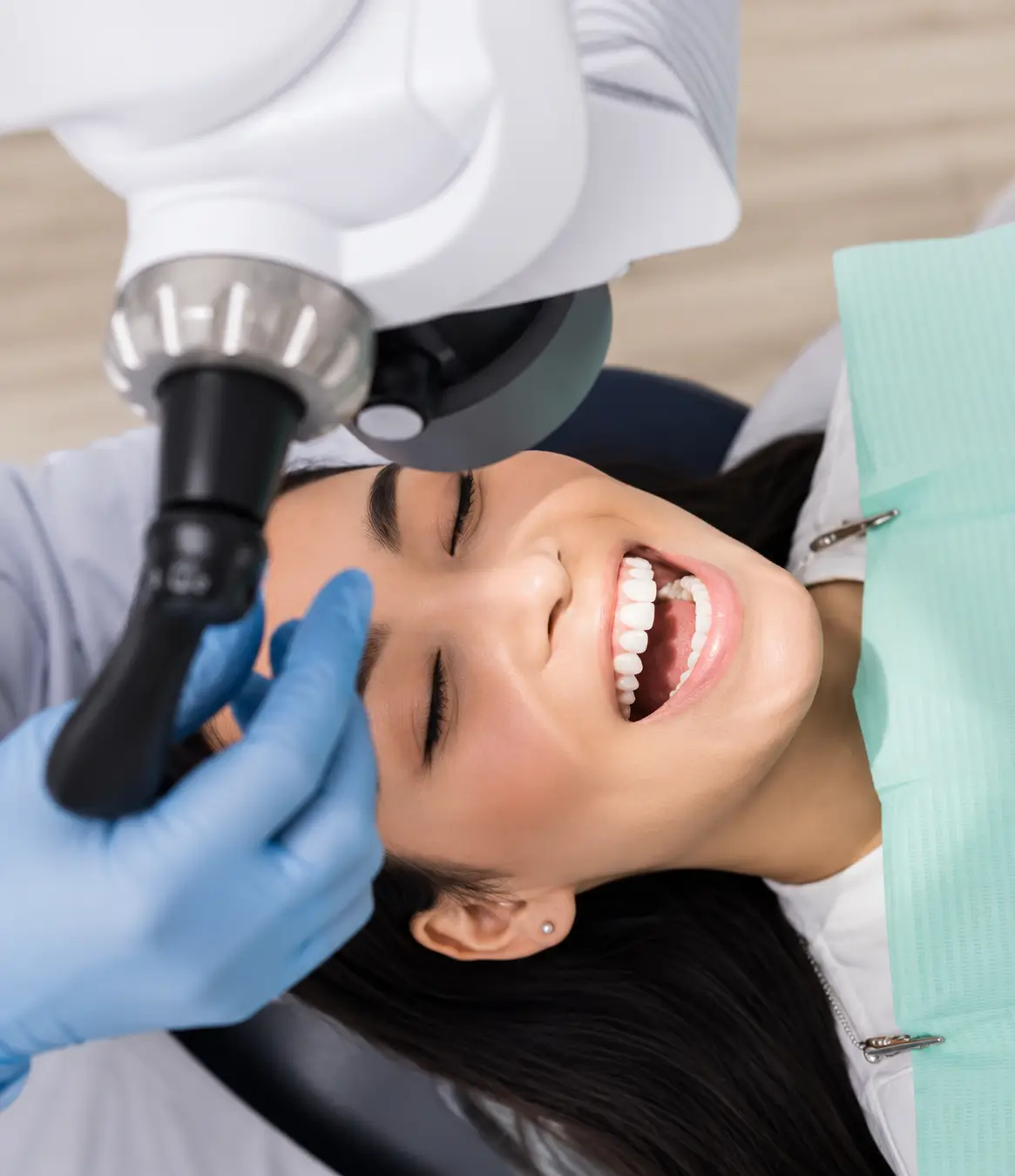 Patient undergoing a routine dental check-up using a dental microscope