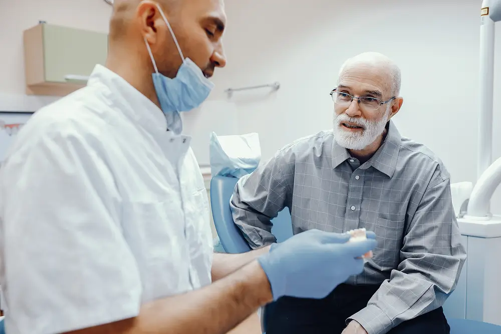 Dentist explaining a dental treatment option to a senior patient during a consultation