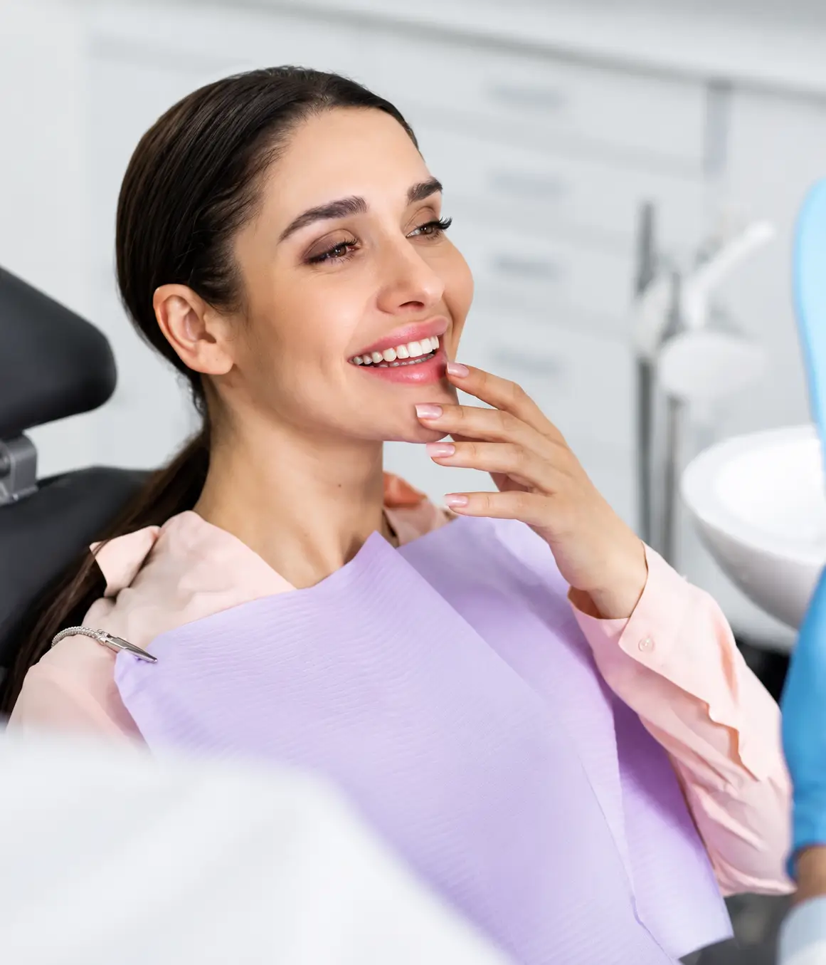 Smiling patient looking in a mirror after a dental appointment