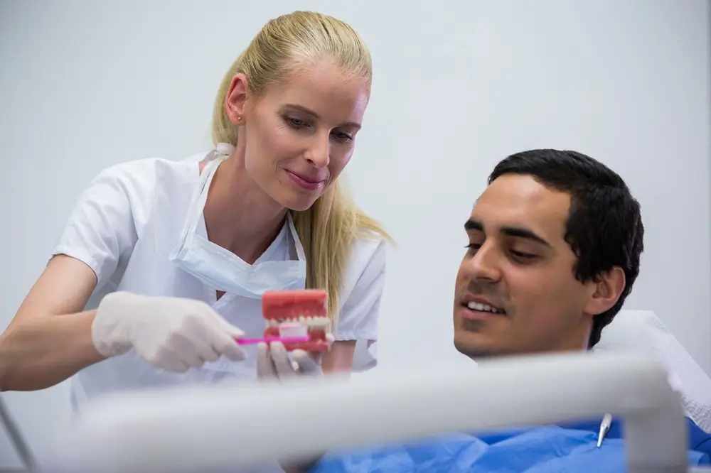 Dentist explaining tooth extraction using a dental model
