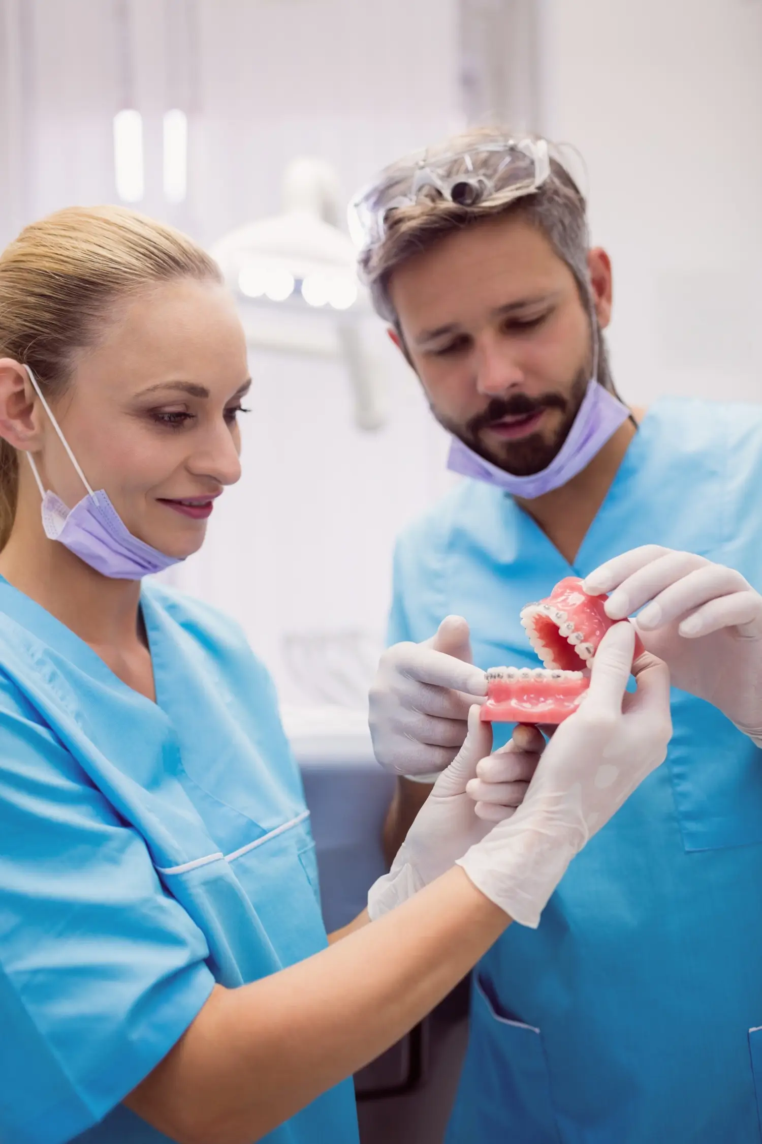 Two clinicians examining a dental model