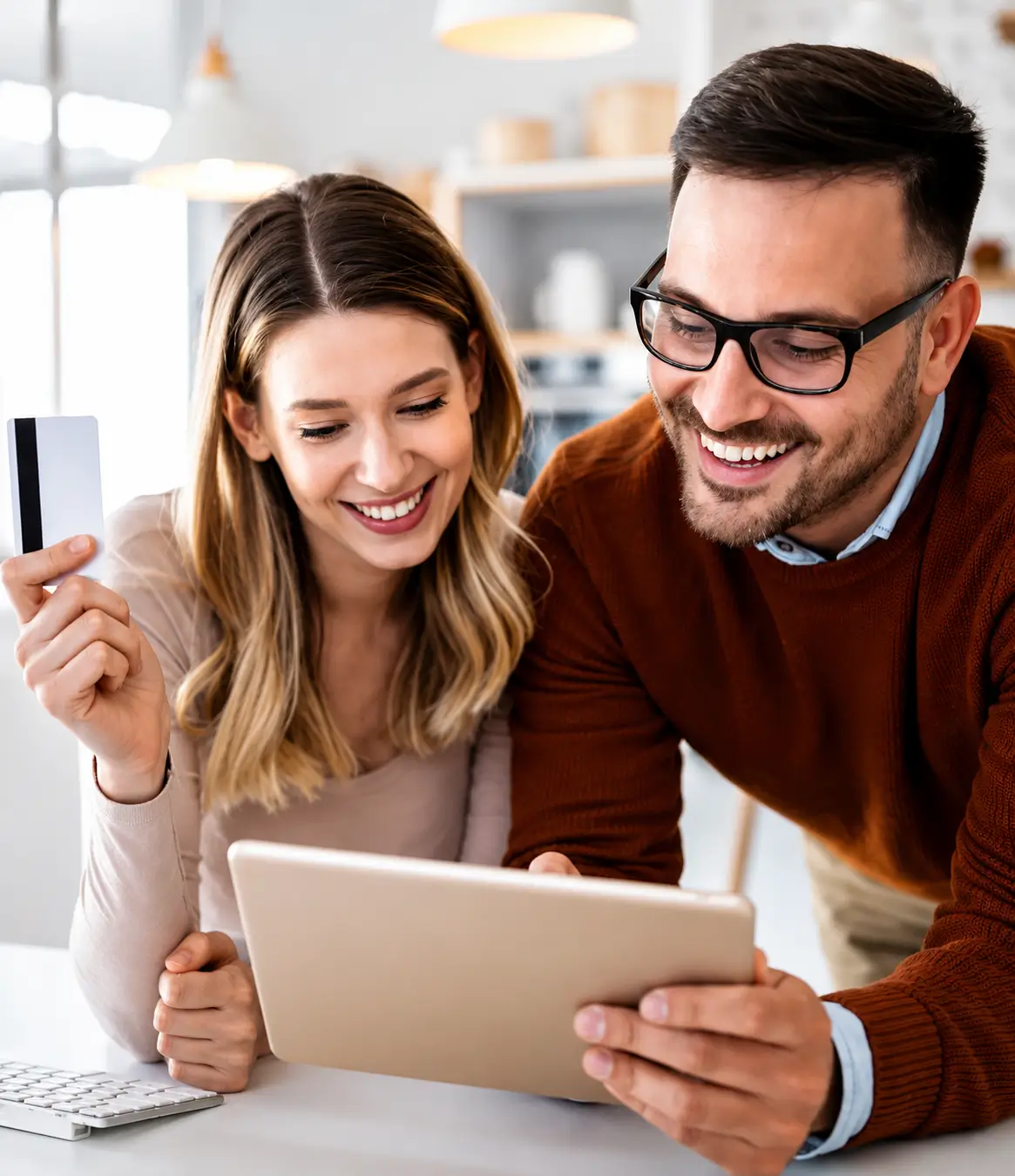Two people using a tablet and holding a payment card