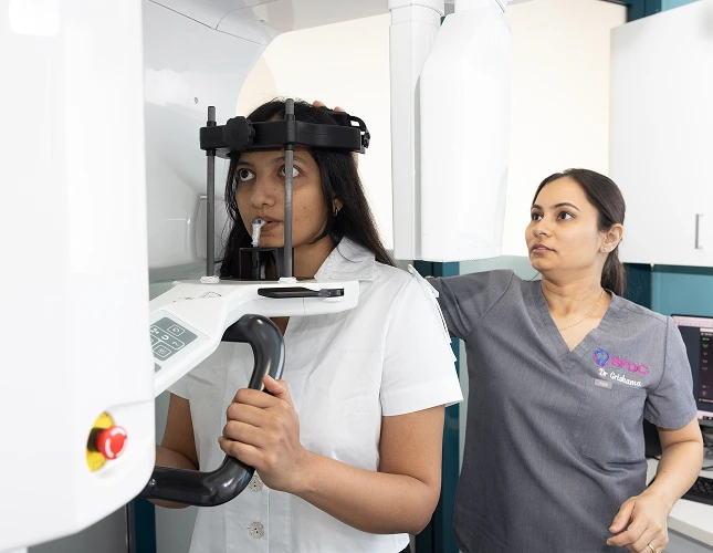 dentist assisting person dental imaging machine