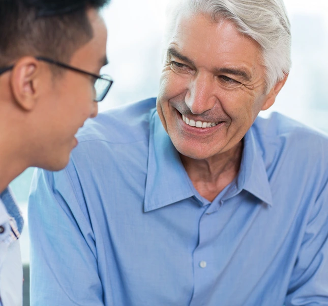 Dentist discussing implant retained dentures with a man