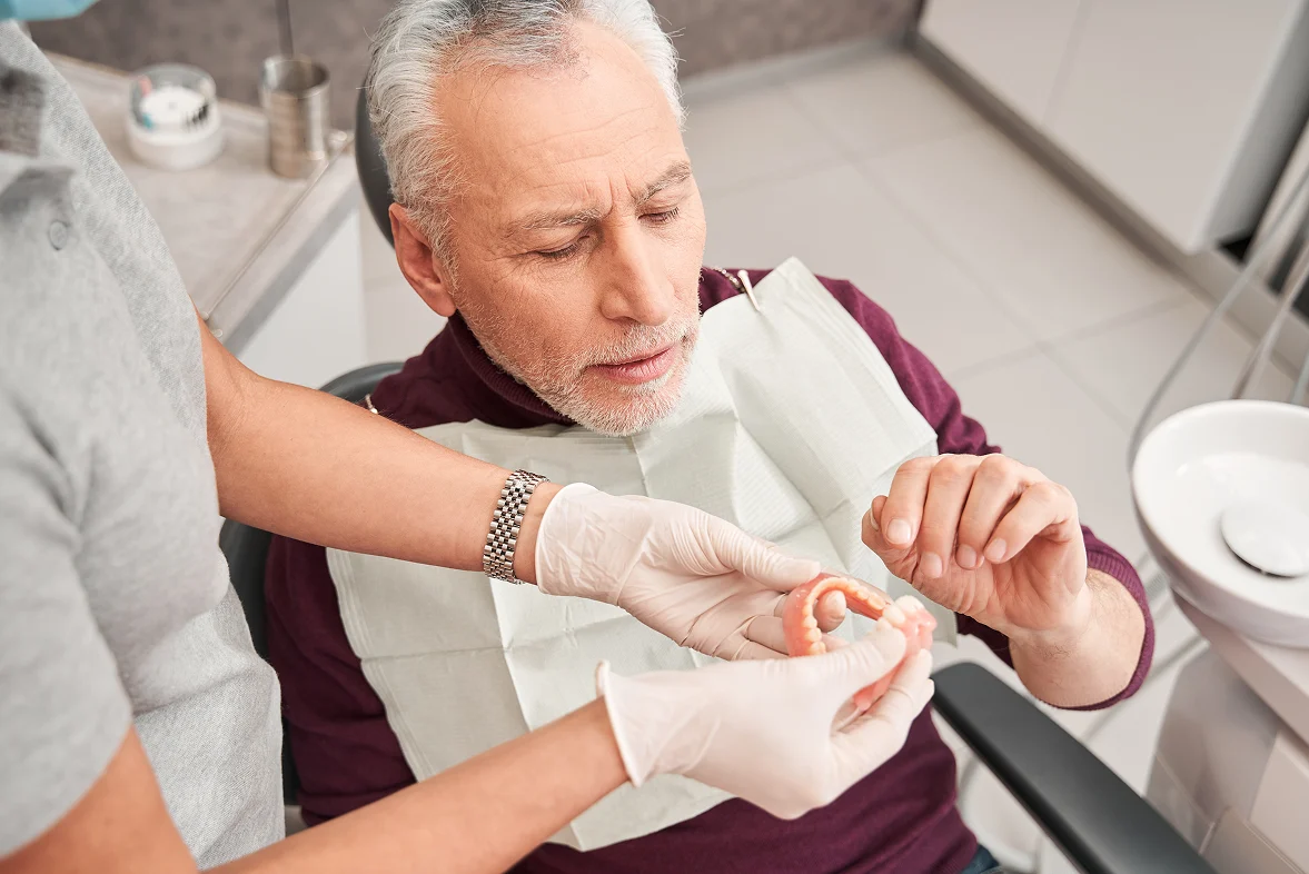 Senior patient reviewing dentures with a dental professional