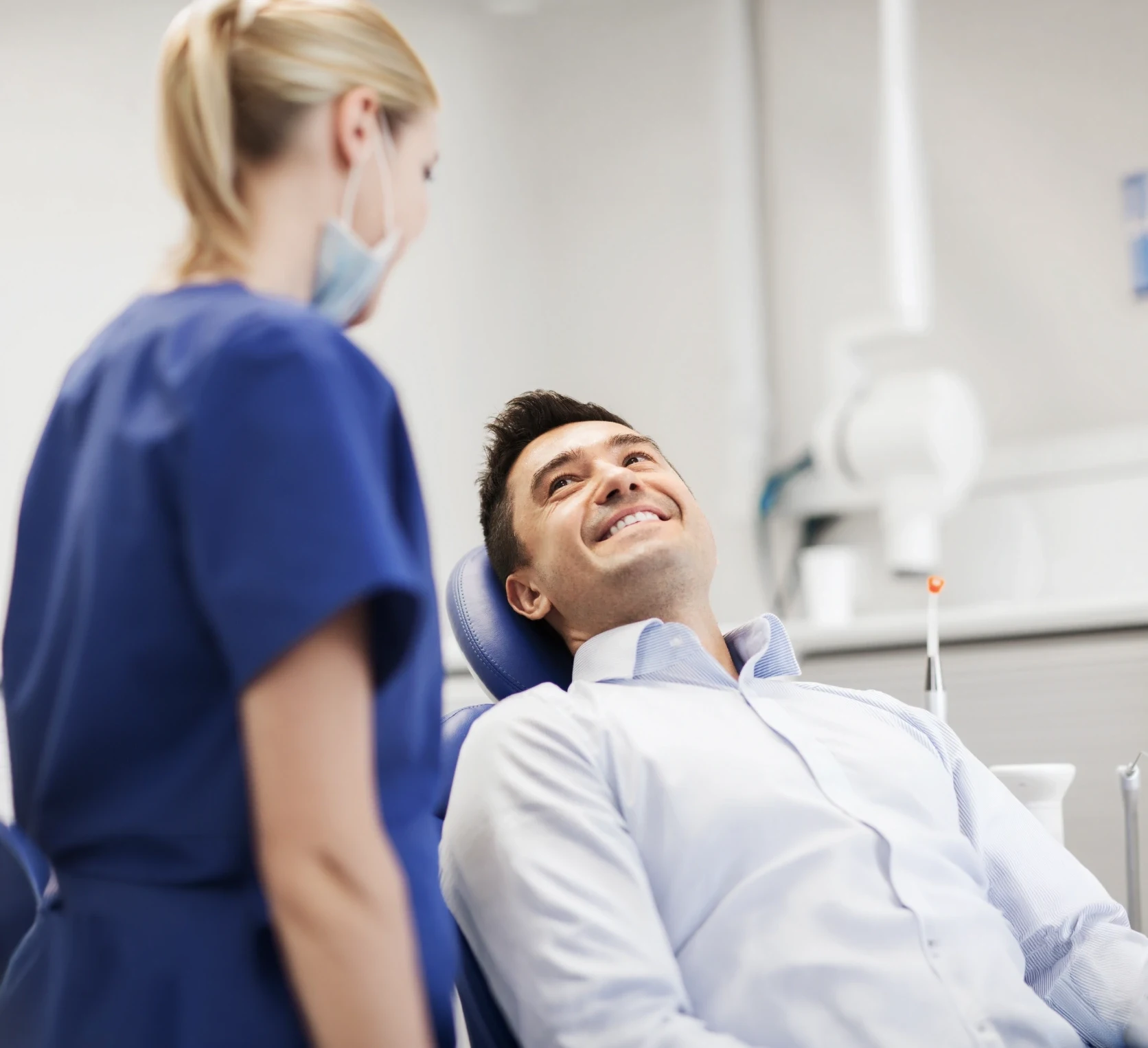 Smiling patient speaking with a dental professional during a clinic visit